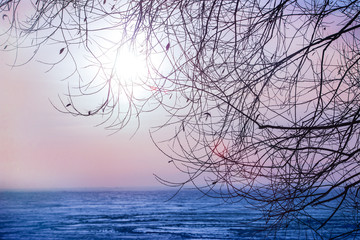 sunset over the winter ice surface of the lake