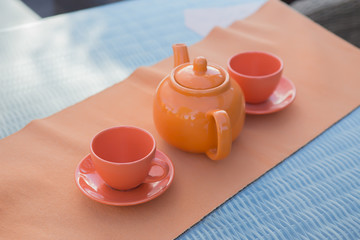 kettle and two cups on the table outside