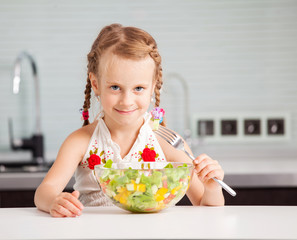 Little girl eating vegetable salad