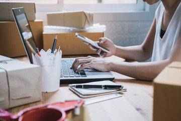Young startup small business entrepreneur woman working with smart phone at home, Online business and delivery concept