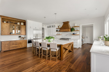Beautiful Large Kitchen in New Home with Dark Hardwood Floors and Accents, and White Counters, Cabinets, and Backsplash