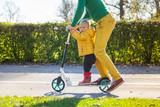 Adorable infant son riding on scooter in public playground, Zagreb, Croatia.