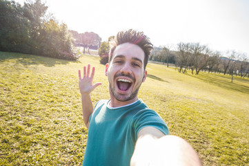Happy man taking a selfie at the park 
