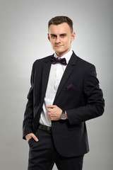 Young businessman on gray background