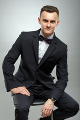 Young businessman on gray background