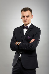 Young businessman on gray background