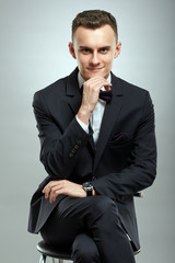 Young businessman on gray background