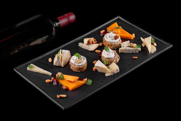 cheese plate with a bottle of red wine