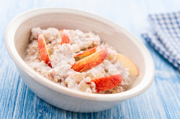 Homemade Porridge with Buckwheat jogurt and sliced apple in bowl