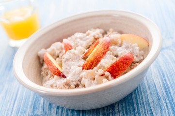 Homemade Porridge with Buckwheat jogurt and sliced apple in bowl