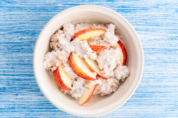 Homemade Porridge with Buckwheat jogurt and sliced apple in bowl