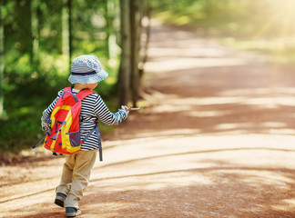 boy going camping with backpack in nature