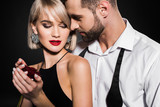 handsome man hugging girlfriend with rose flower, isolated on black