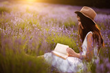 Woman at lavender flower field in summer sunset