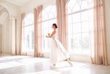 Young ballerina dancing in a white studio