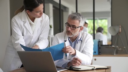 Medical people working together on patient file, hospital office