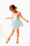 Cute little child girl in light blue dress plays in the ballet. Vertical image.