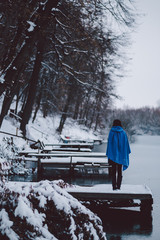 Woman standing on pier at a winter lake