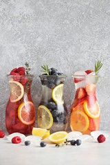 Berry infused water, coctail, lemonade or tea. Summer iced cold drinks with strawberry, blueberry, raspberry, lemon and herbs Selective focus