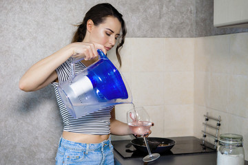 Woman pours clean filtered water.