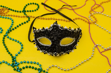 Traditional Venice carnival mask. Man and woman ball masque for theater or opera, mardi gras festival or brazil parade. Fashion and holiday theme with colorful beads on yellow background