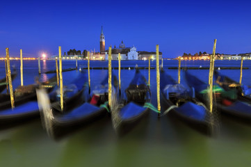 Venice gondole on a blue sunset twilight and San Giorgio Maggiore church landmark on background. Italy Europe.