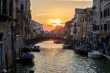 View of Venice at sunset. A ray of sunshine in the frame. A beautiful Italian city with canals and historic architecture.