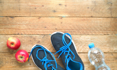 Getting fit and reducing weight, pair of sports shoes, apples bottle of water,concept,free copy space,flat lay