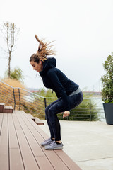 Fitness woman jumping outdoor in urban enviroment