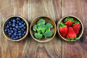 Wooden Bowls Filled With Healthy Fresh Fruit on a Rustic Wooden Background
