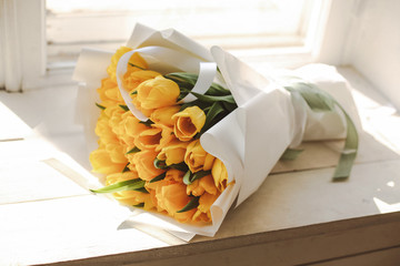 beautiful bouquet of yellow tulips in paper packaging