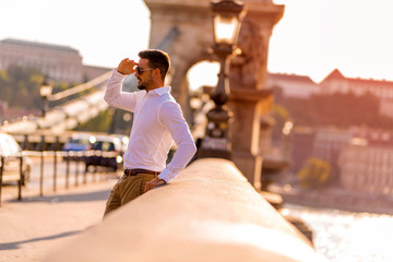 A businessman on a bridge covering his face