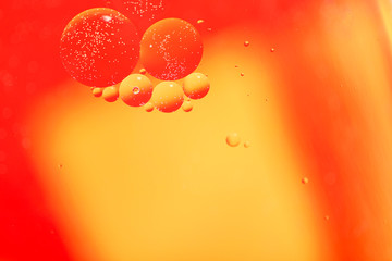 Abstract blurred background. Fluid texture with circles  and drops of red and yellow color. Cropped shooting, macro, horizontal, nobody, free space for text