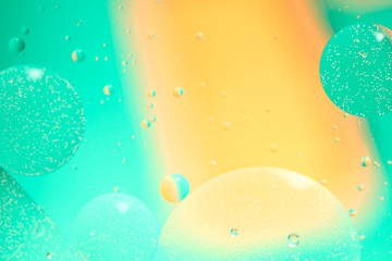 Abstract blurred background. Fluid texture with circles  and drops of green and yellow. Cropped shooting, macro, horizontal, nobody, free space for text.