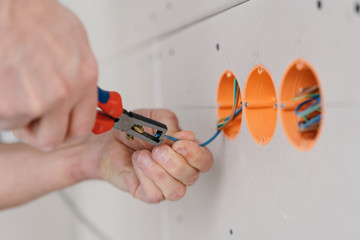 Handyman stripping an electric wire
