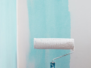 Person applying paint on wall