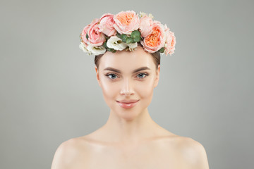 Pretty woman with healthy skin and rose flowers wreath portrait. Pretty candid girl with flowers. Facial treatment, skin care and cosmetology concept