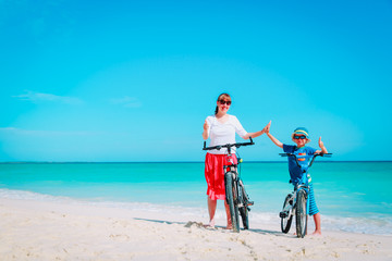 Happy mother and son biking at beach