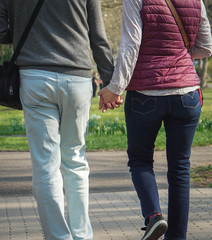 Paar hält Händchen beim Spaziergang