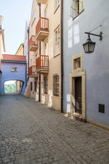 Narrow street with an arch and old lanterns. Warsaw.