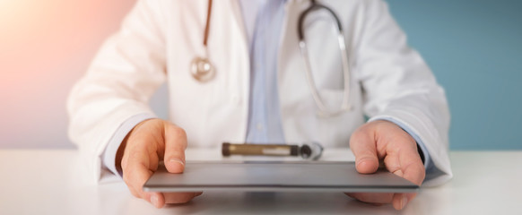 Doctor using modern tablet to read analysis results