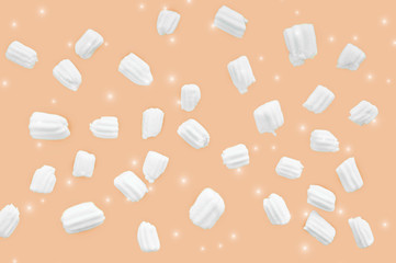 marshmallows for coffee and glitter on an orange background