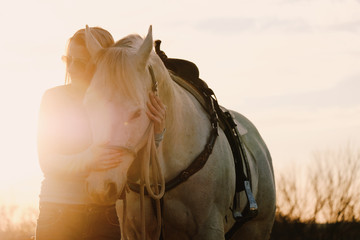 Woman with horse during sunset on farm.  Western industry agriculture concept.