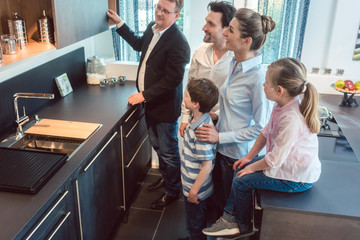 Family with kids looking at a kitchen in showroom