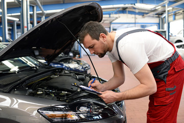 Check am KFZ durch Automechaniker in einer Werkstatt // Check at the motor vehicle by a car mechanic in a workshop 