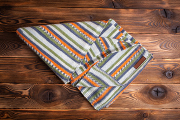 knitted scarf with colored stripes on a wooden background