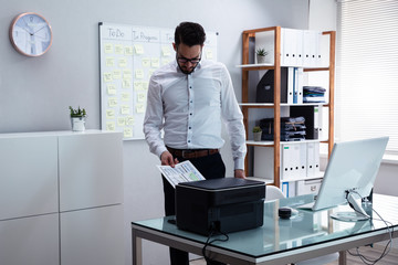 Businessman Using Printer In Office