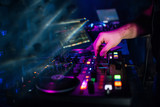 hands DJ playing and mixing music on music controller at a party