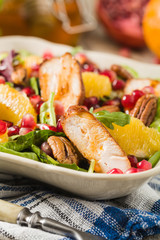 Spring salad with chicken, pomegranate, orange, pecan nuts and honey.