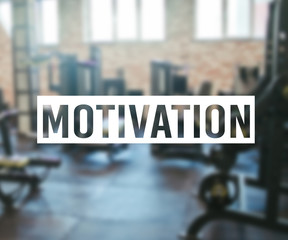 Word Motivation on blurred background of gym with equpment.